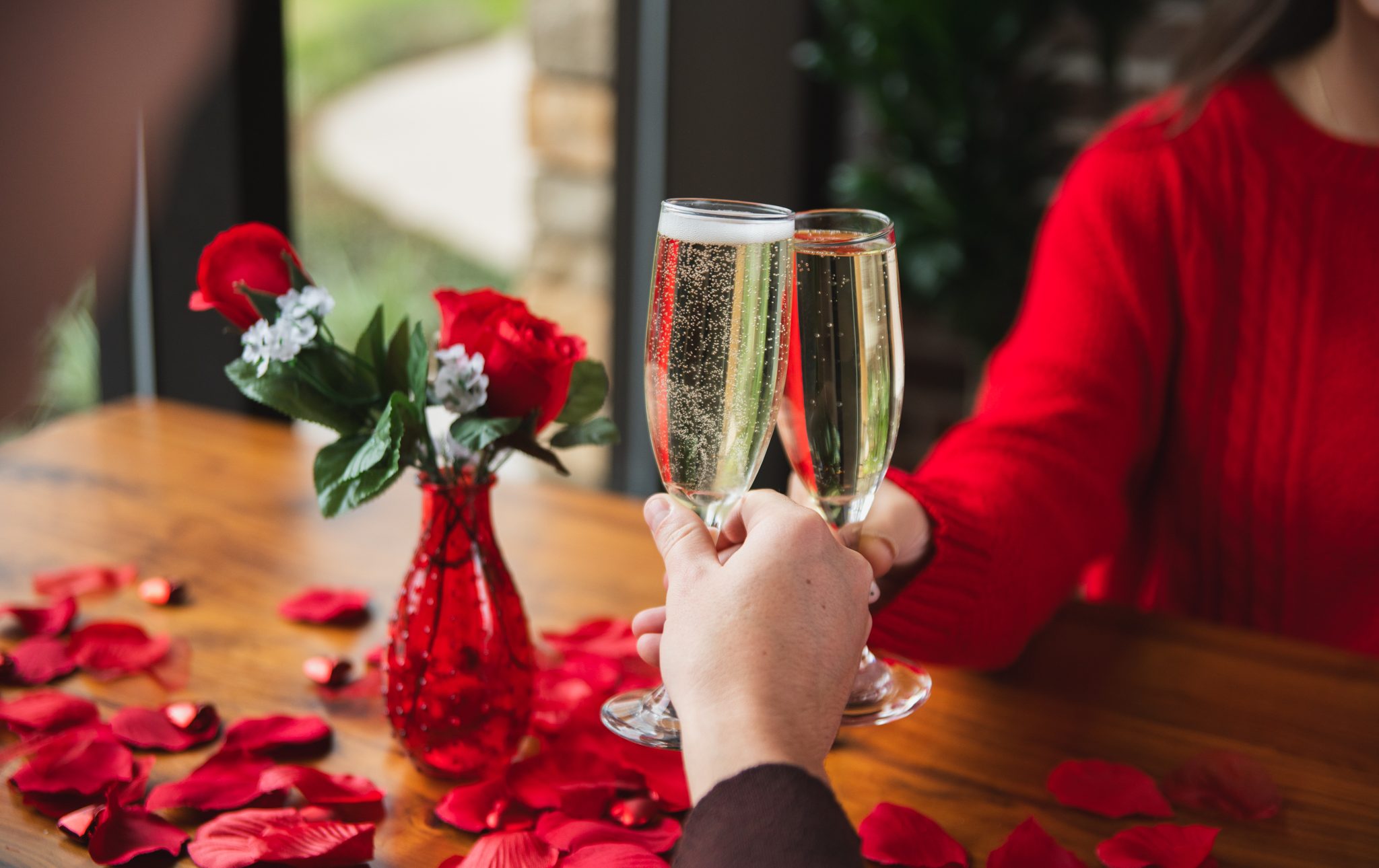 image of champagne cheers for Valentine's in Back Table at The Woodland Resort